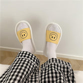 Sandalias de goma con estampado de sonrisas en negro, blanco y amarillo